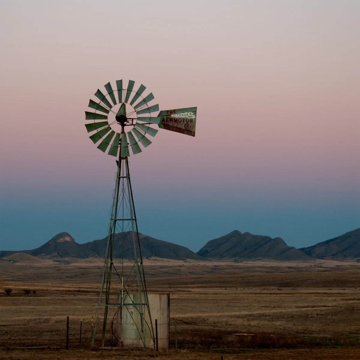 A farm windmill water pump on open rangeland